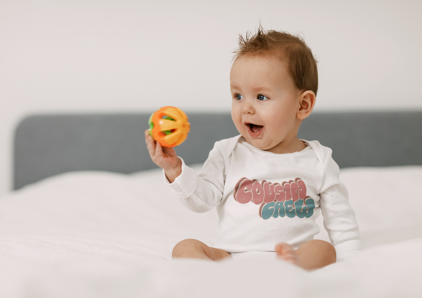 Long Sleeve Onesie with a groovy printed graphic and the text 'Cousin Crew.' This trendy and cool design celebrates the bond of cousins in a unique and stylish way.