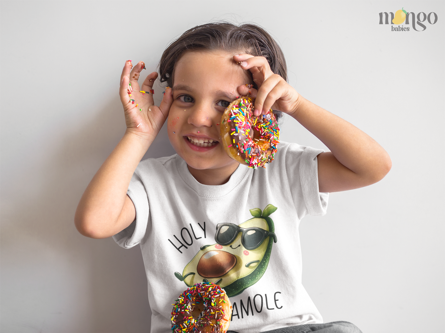 Cute avocado graphic with “Holy Guacamole” text printed on baby bodysuit, kids T-shirt, children’s sweater, and unisex adult shirt.