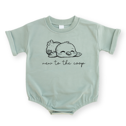 Minimalist "New to the Coop" baby romper in Sage green featuring a simple line drawing of a baby chicken and modern text.