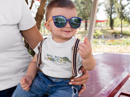 Cute dinosaur graphic with “Small But Mighty” text on baby bodysuit, kids’ t-shirt, sweatshirt, and unisex adult shirt.