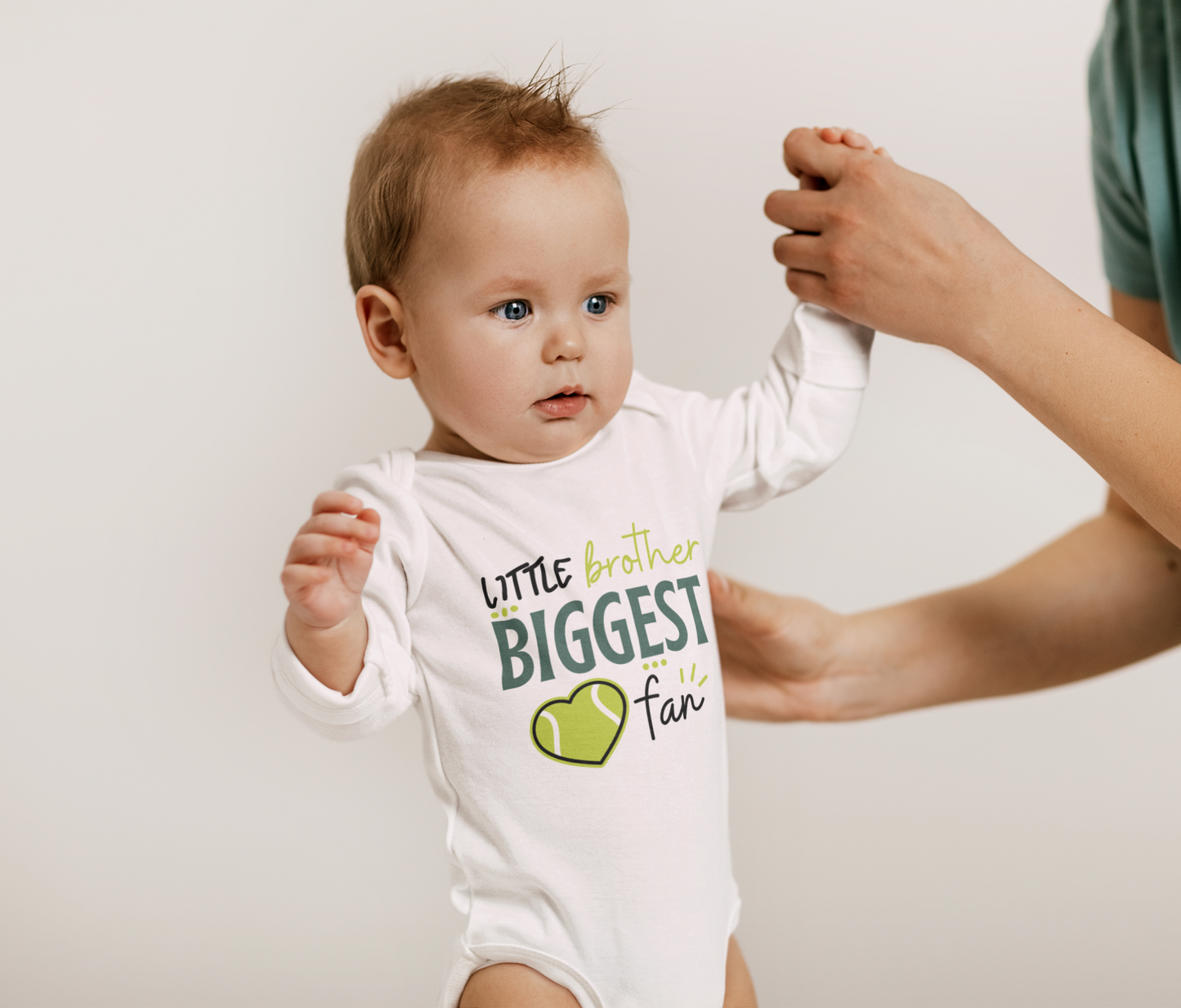 Baby and kids shirt with “Little Brother Biggest Fan” text and cute tennis design, available as a onesie or T-shirt.
