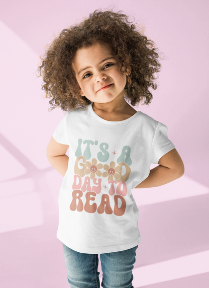 Retro “It’s a Good Day to Read” design on baby onesie, toddler tee, and kids’ t-shirt, promoting reading and learning.
