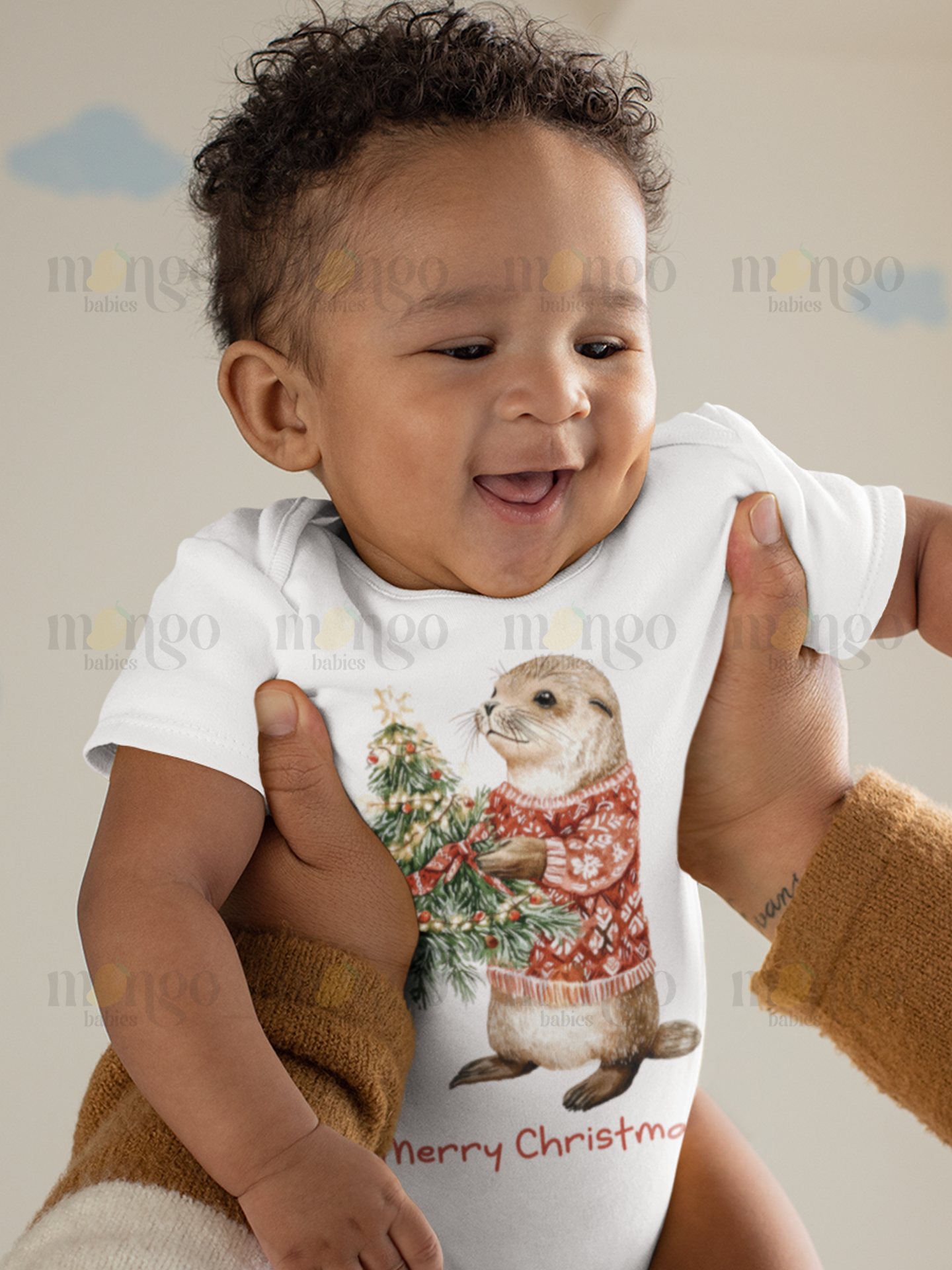 Cute otter wearing a Christmas sweater with “Merry Christmas” text on baby bodysuit, kids t-shirt, sweatshirt, and adult unisex shirt.