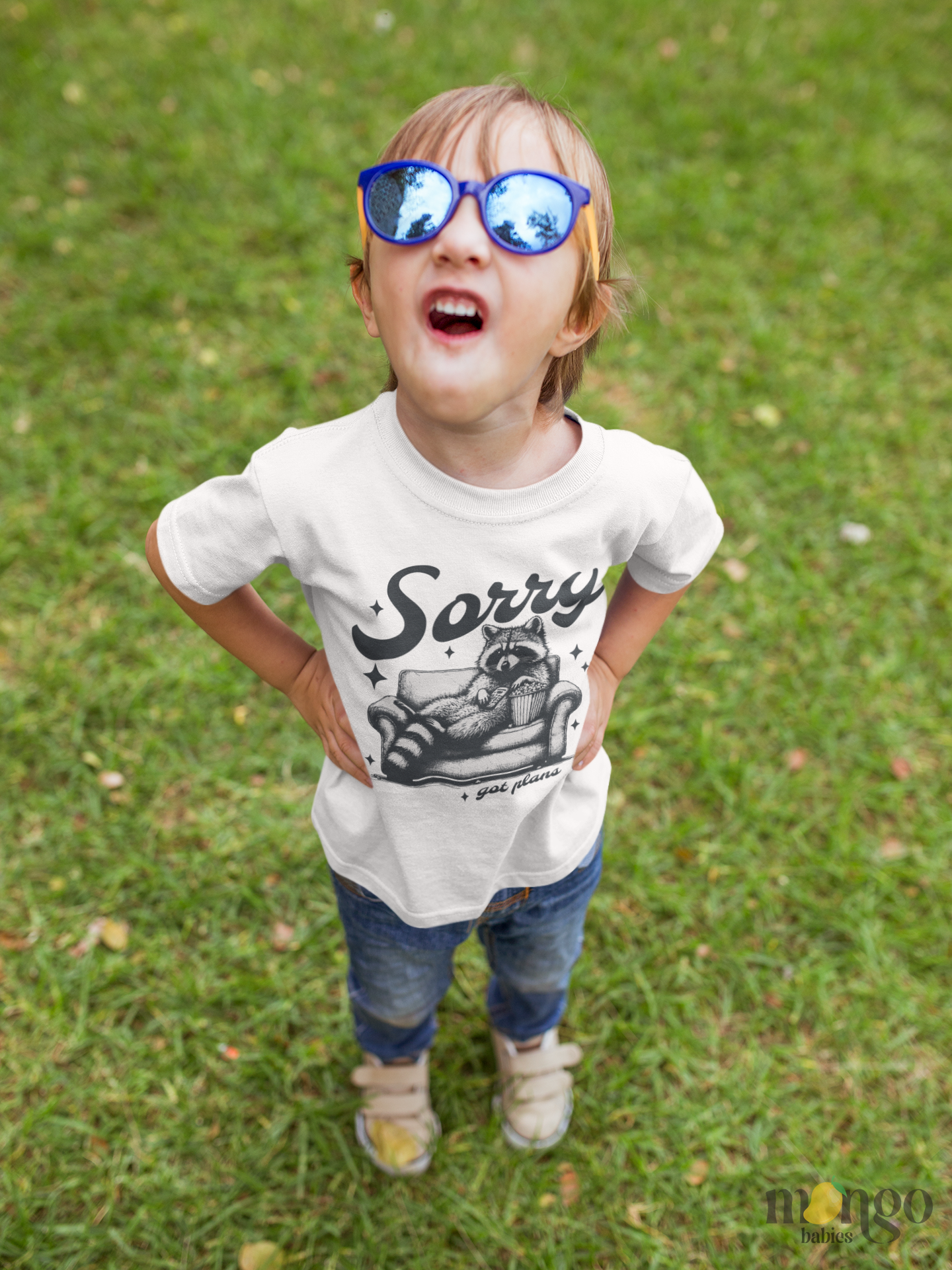 Cute raccoon sitting on a couch with text “Sorry Got Plans” printed on baby onesie, toddler t-shirt, and kids’ shirt.
