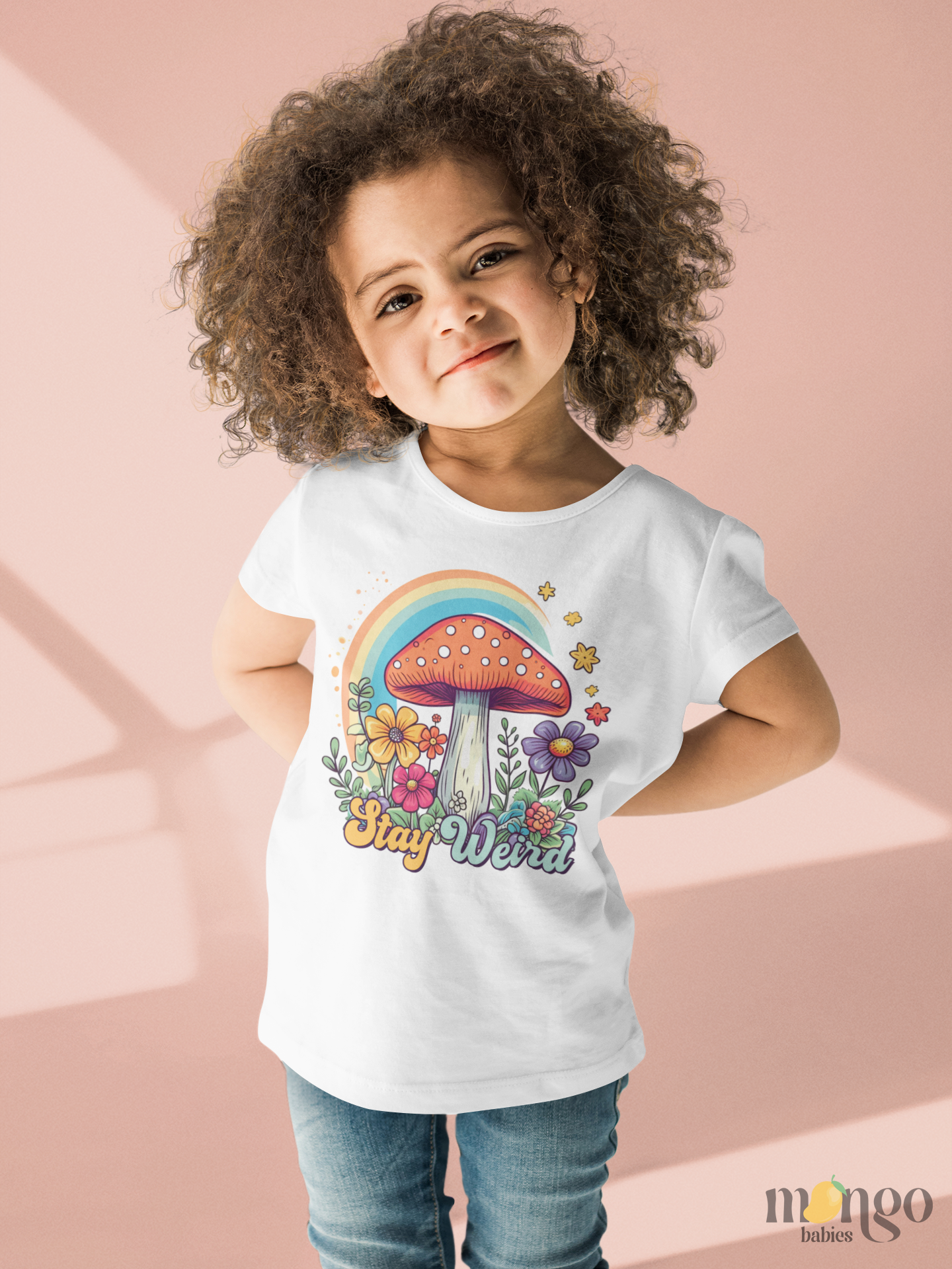 Retro mushroom and rainbow “Stay Weird” design printed on baby bodysuit, kids’ T-shirt, children’s sweater, and unisex adult shirt.
