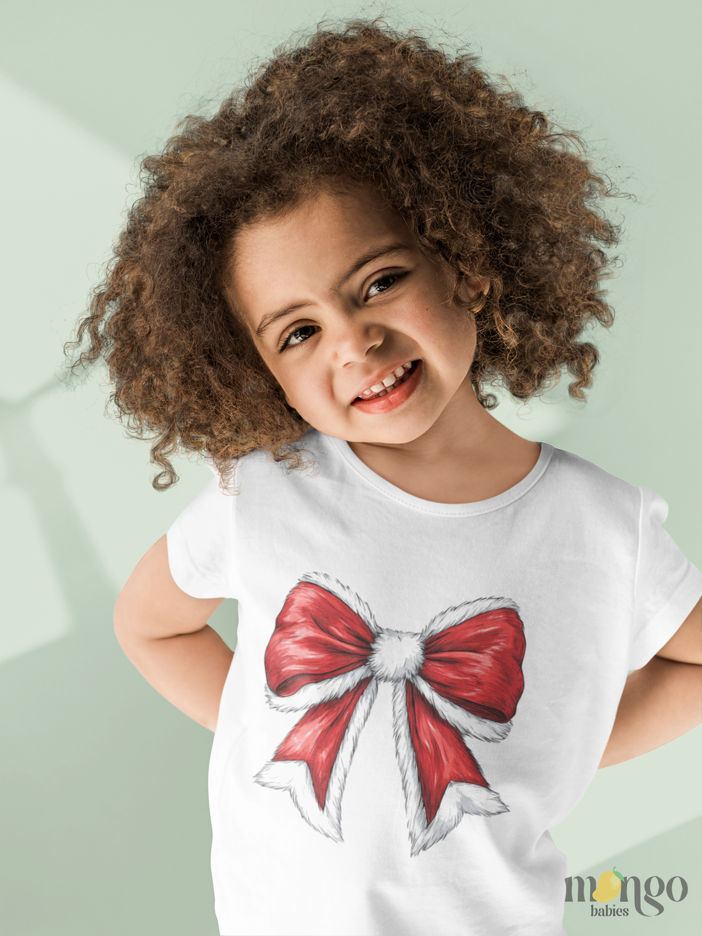 Christmas red bow printed design on baby bodysuit, kids’ t-shirt, children’s sweatshirt, and unisex adult shirt.