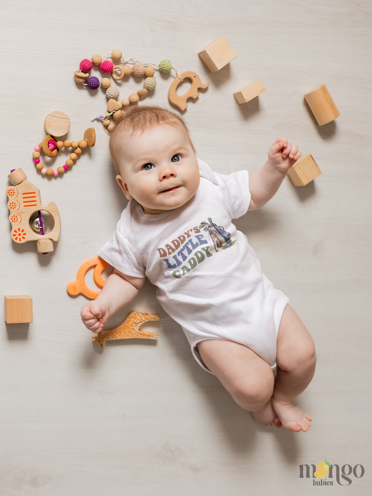 Baby bodysuit, kids t-shirt, sweatshirt, and adult unisex shirt with cute golf caddy design and text “Daddy’s Little Caddy.”