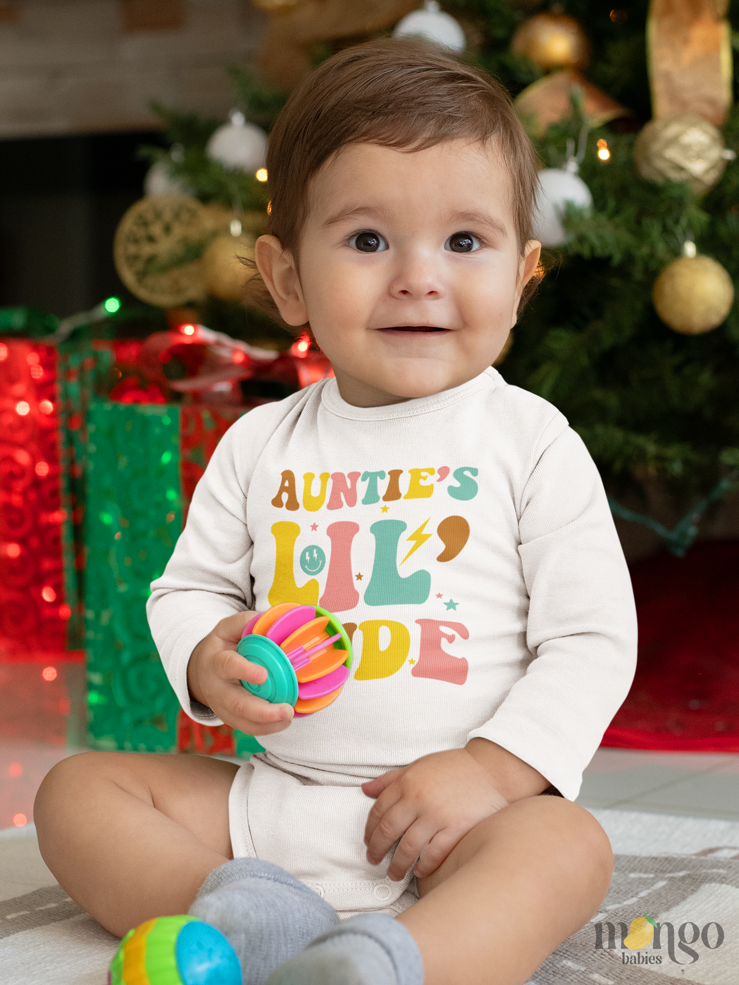 Baby bodysuit and kids’ t-shirt with retro text design “Auntie’s lil dude” in colorful lettering.