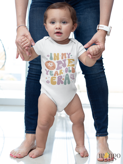 Pastel retro “In My One Year Old Era” baby bodysuit with flowers and butterflies, available in toddler and kids’ shirt sizes.

